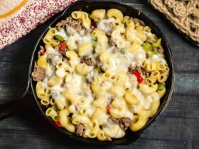 Skillet meal with pasta, thinly sliced steak, onions, peppers, and melted cheese.