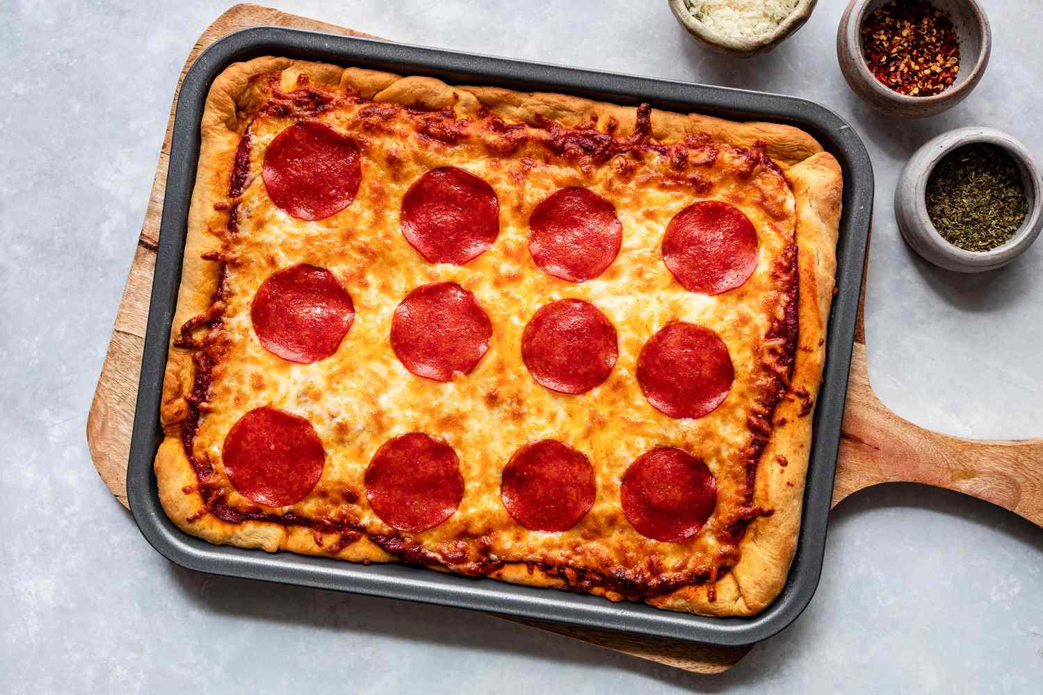 Homemade pizza baked on a sheet pan with assorted toppings.