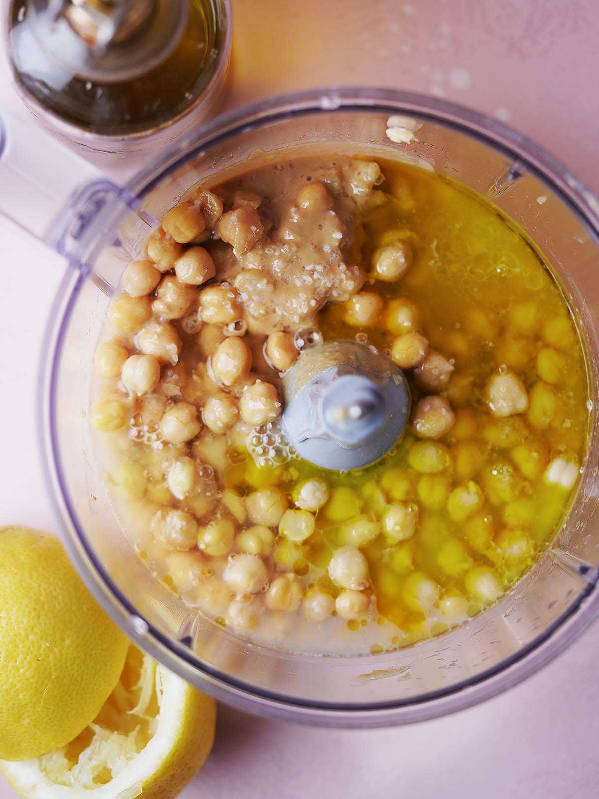 Chickpeas being rubbed with a kitchen towel to remove skins, showing the process of achieving ultra-smooth texture
