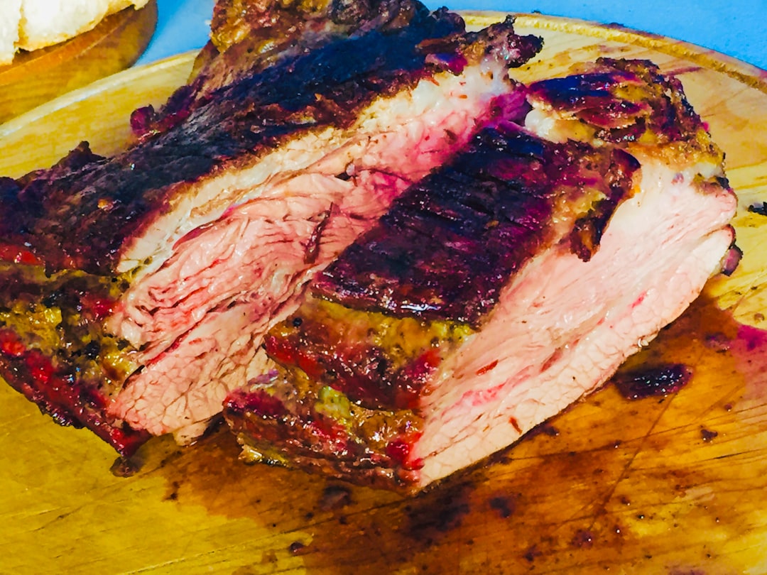 Raw pork shoulder being seared in a cast iron skillet with visible browning and caramelization