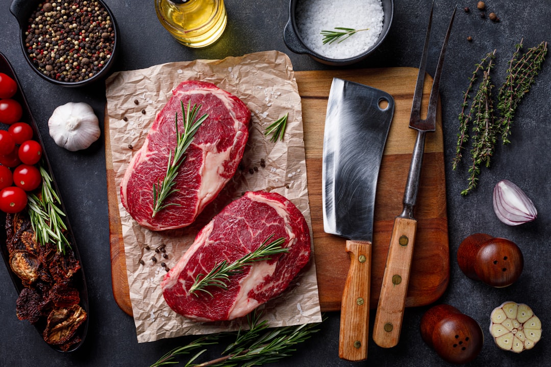 Ingredients for Japanese beef curry laid out on a wooden cutting board, including curry roux blocks, chunks of raw beef, diced onions, carrots, and potatoes