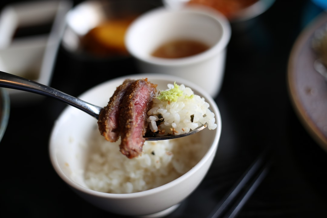 Close-up shot of a spoonful of Japanese beef curry showing the glossy, rich texture with visible tender beef chunks and vegetables
