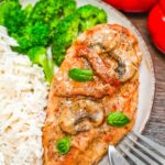 Marry Me Chicken served on elegant white plates with creamy sun-dried tomato sauce, fresh basil garnish, and golden seared chicken thighs