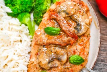 Marry Me Chicken served on elegant white plates with creamy sun-dried tomato sauce, fresh basil garnish, and golden seared chicken thighs