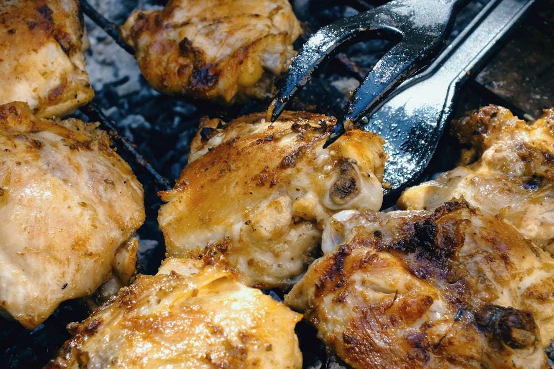 Close-up shot of a fork lifting a piece of golden, herb-crusted chicken with creamy tzatziki dripping, showing the juicy interior