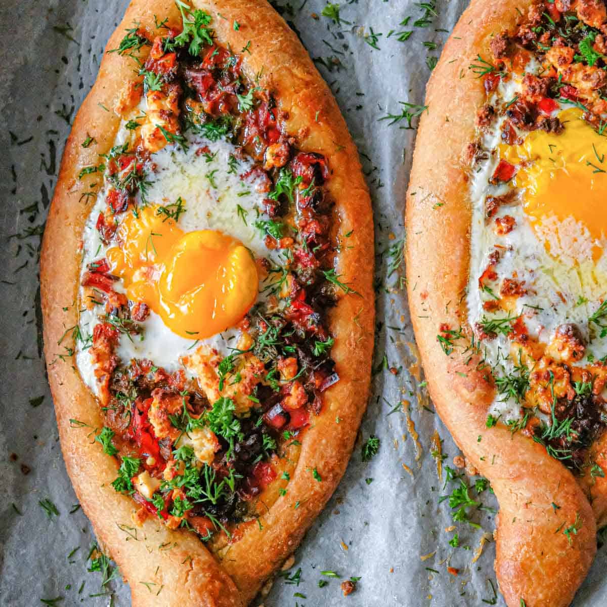 Close-up shot of shakshuka being served with crusty bread, showing the golden yolk mixing with rich tomato sauce