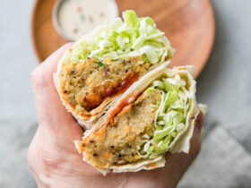 Trader Joe's style spicy lentil wrap cut in half showing colorful filling with lentils and vegetables on rustic wooden board