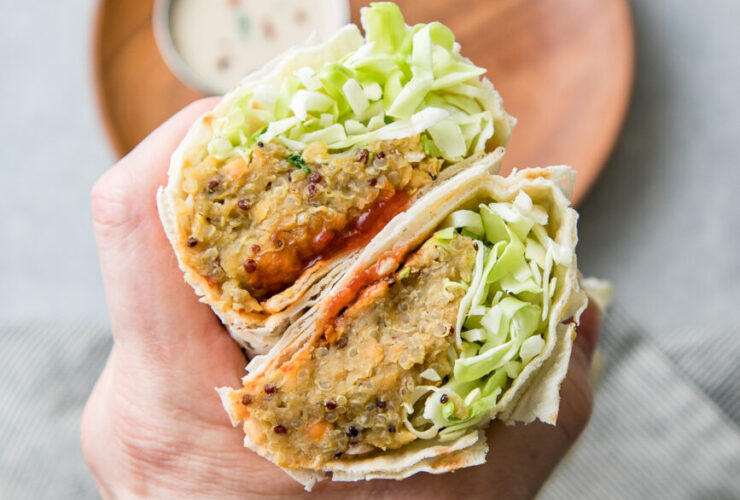 Trader Joe's style spicy lentil wrap cut in half showing colorful filling with lentils and vegetables on rustic wooden board