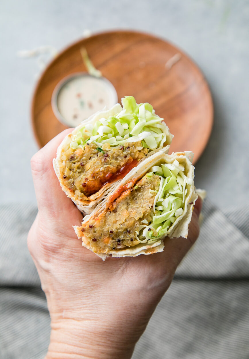 Trader Joe's style spicy lentil wrap cut in half showing colorful filling with lentils and vegetables on rustic wooden board