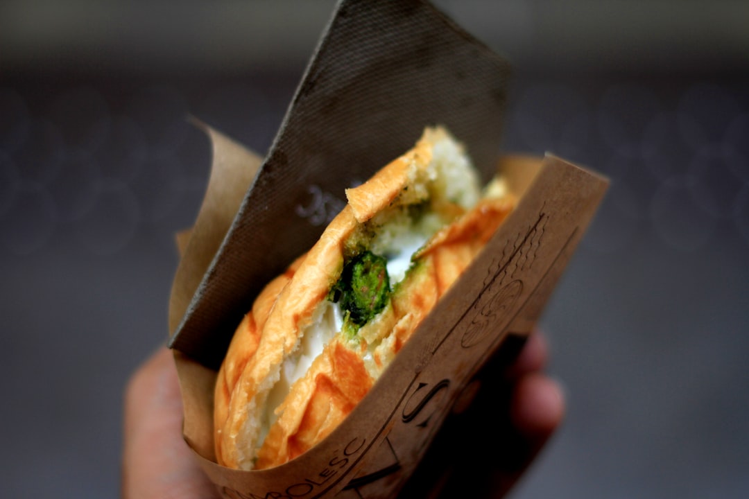 Stunning Banh Mi sandwich cut in half showing layers of marinated pork, pickled vegetables, fresh herbs, and pâté on crusty Vietnamese baguette