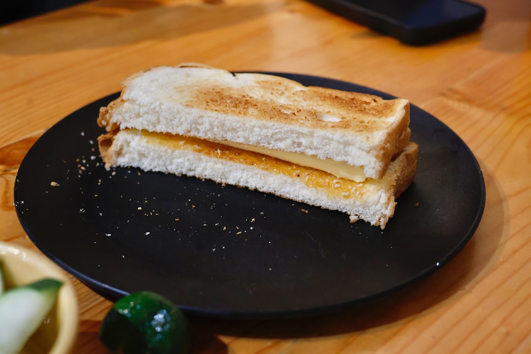 Close-up shot of Banh Mi sandwich being held, showing the beautiful layers and textures with pickled vegetables and herbs spilling out