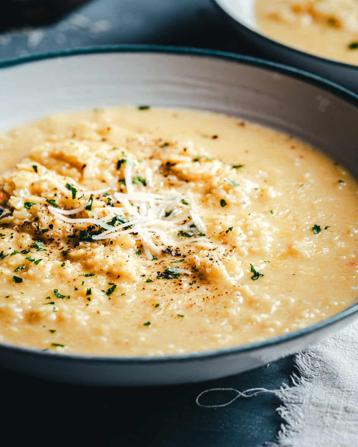 Close-up of buttered pastina on a spoon showing creamy texture and melted cheese