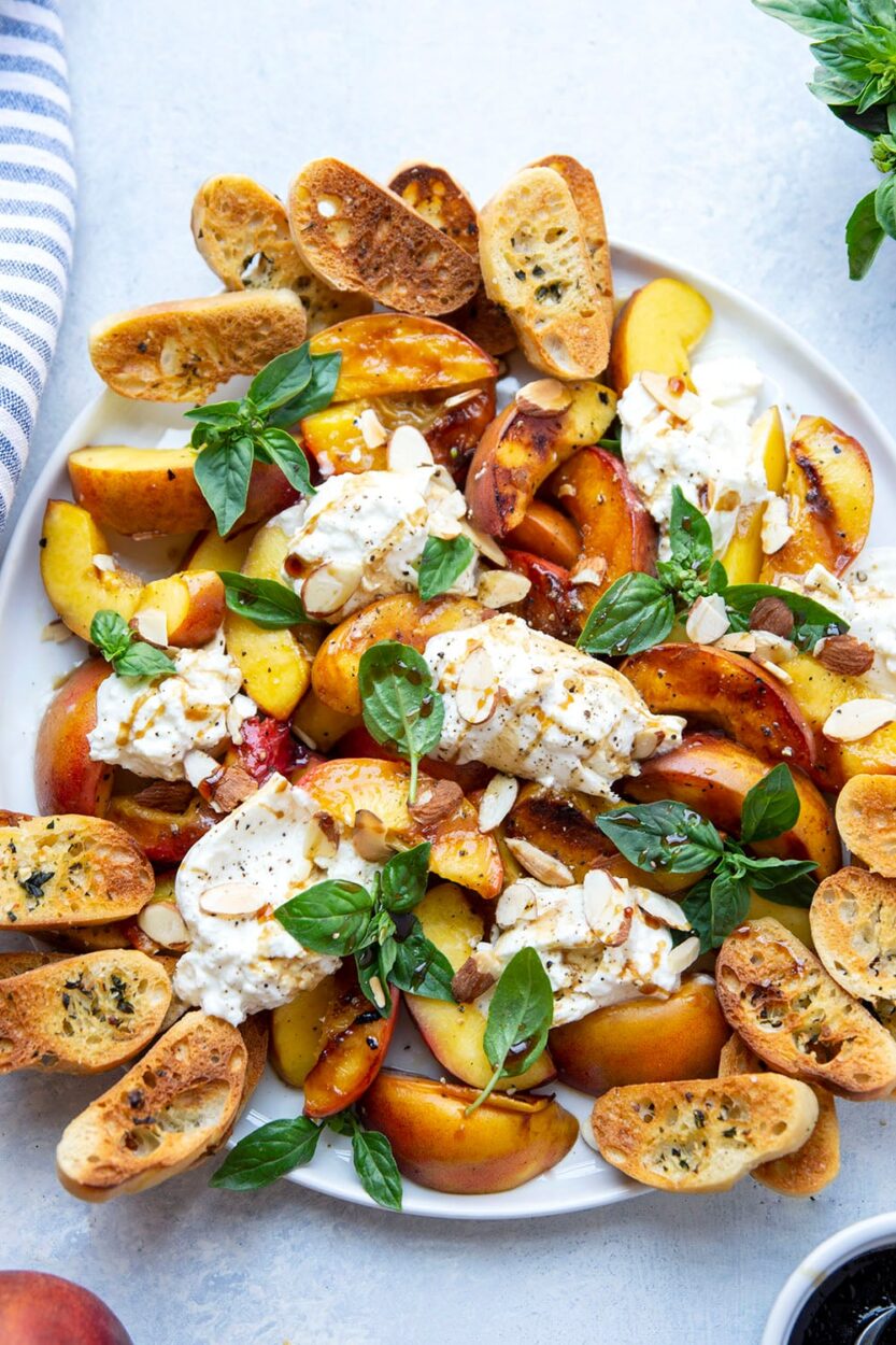 Step-by-step shot showing peach wedges being grilled with beautiful caramelization and grill marks, alongside fresh burrata and herbs