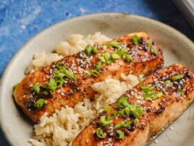 Perfectly glazed salmon fillet with caramelized miso coating, garnished with sesame seeds and scallions on a white plate