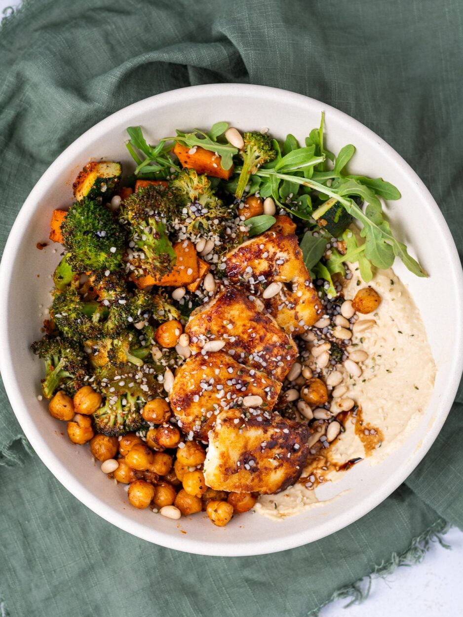 Close-up of roasted chickpea hummus bowl showing crispy golden chickpeas, creamy hummus swirl, fresh herbs and a drizzle of olive oil with za'atar