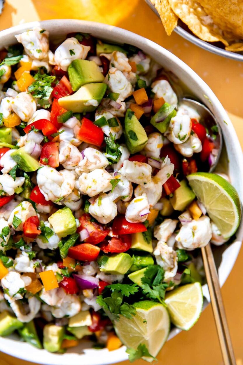 Close-up shot of a spoonful of shrimp ceviche showing the tender shrimp and vibrant vegetables, perfect for serving suggestions