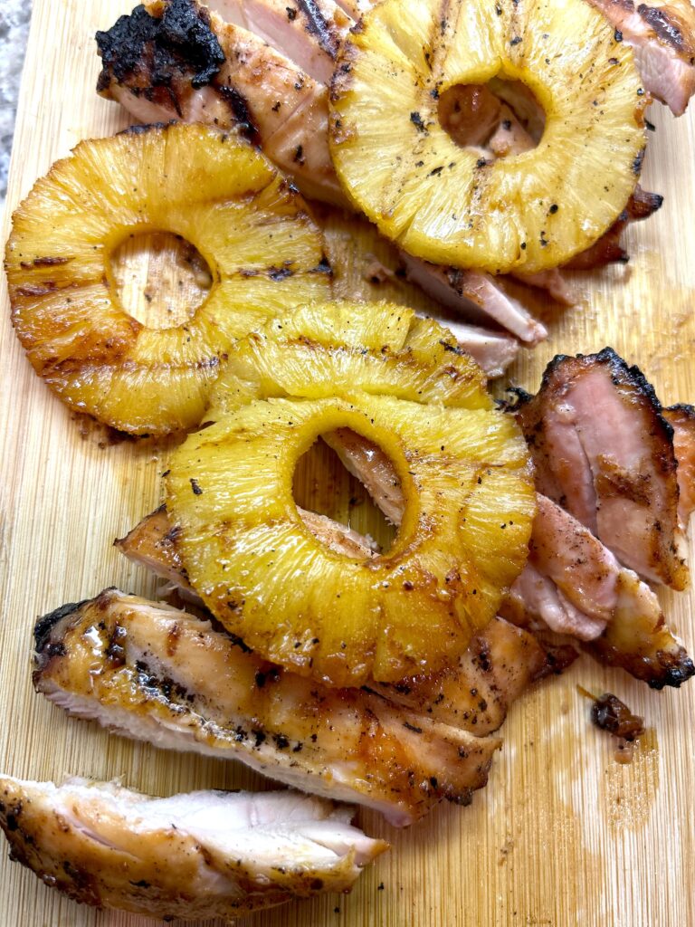 Huli Huli Chicken marinade ingredients in bowls — pineapple juice, soy sauce, brown sugar, ginger, and garlic on a wooden board