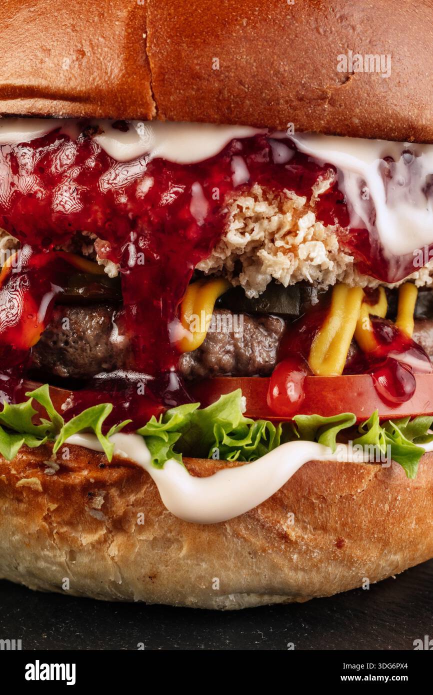 Close-up of a Classic Cheeseburger cross-section showing juicy medium-cooked beef patty, melted American cheese dripping over the sides, crisp lettuce, fresh tomato, and burger sauce on a toasted brioche bun