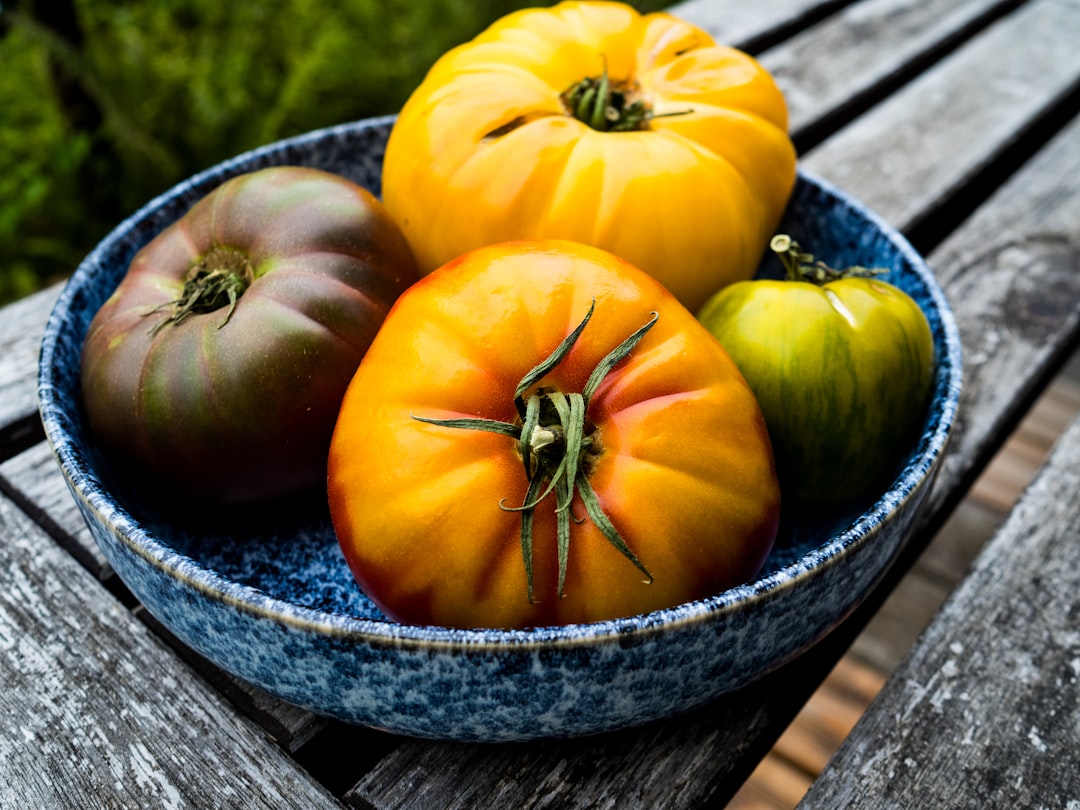 Heirloom tomato galette with golden flaky crust and colorful tomato slices on a rustic wooden board