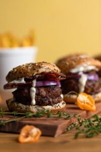 Juicy turkey burger stacked high with lettuce, tomato, caramelized onions, and special sauce on a toasted brioche bun, served on a wooden board with fries