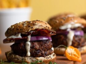 Juicy turkey burger stacked high with lettuce, tomato, caramelized onions, and special sauce on a toasted brioche bun, served on a wooden board with fries