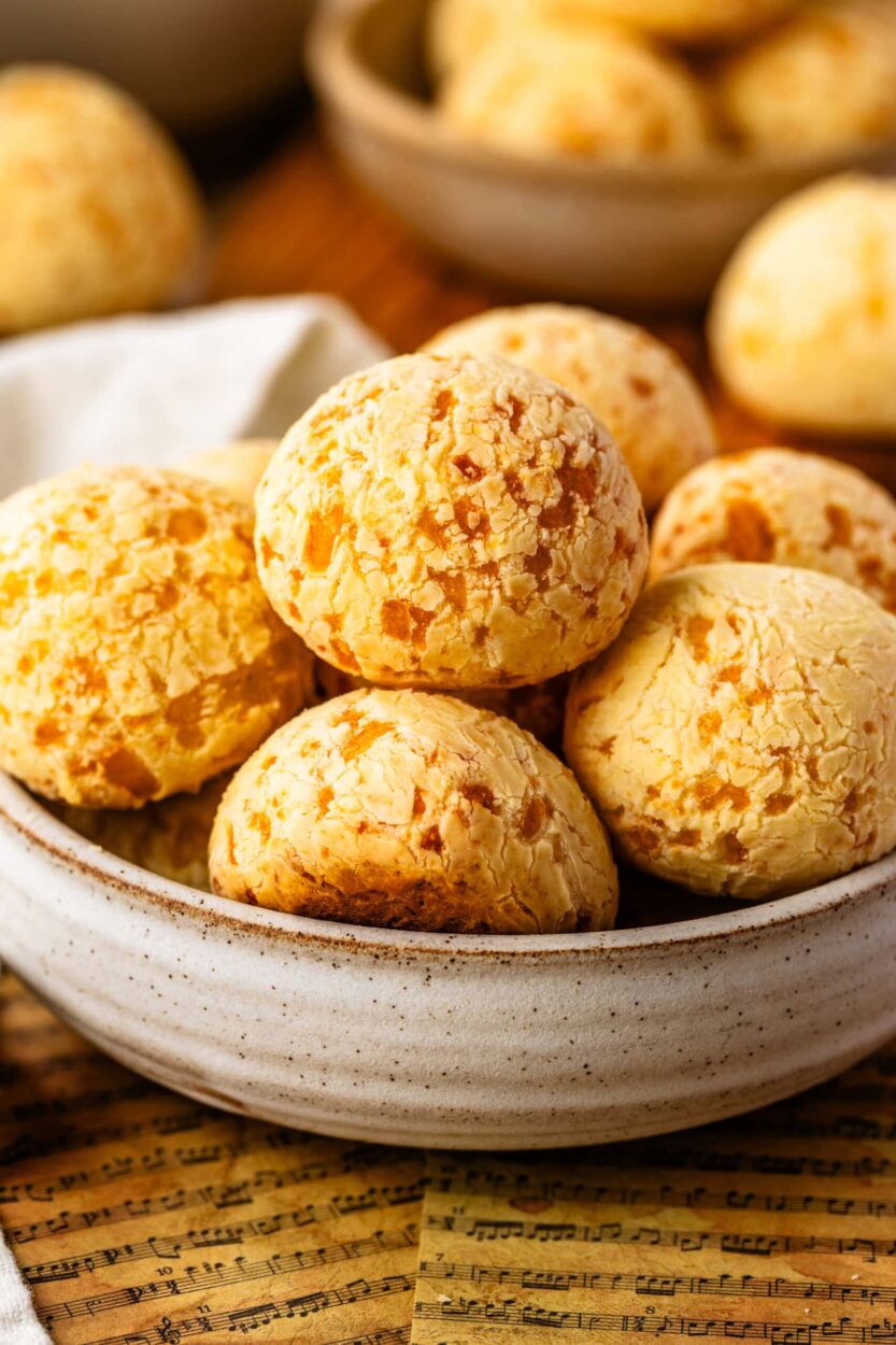 Step-by-step flat lay showing tapioca starch, shredded Parmesan and mozzarella, eggs, milk, and oil measured out in small bowls on a marble surface, with a blender nearby
