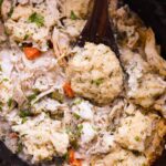 Crockpot Chicken and Dumplings served in a deep white bowl with fluffy dumplings and thick creamy broth, garnished with fresh parsley