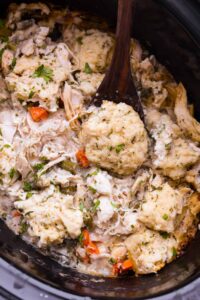 Crockpot Chicken and Dumplings served in a deep white bowl with fluffy dumplings and thick creamy broth, garnished with fresh parsley