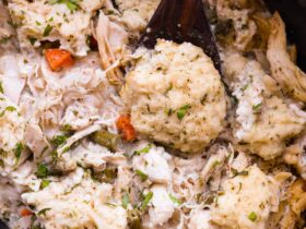 Crockpot Chicken and Dumplings served in a deep white bowl with fluffy dumplings and thick creamy broth, garnished with fresh parsley