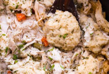 Crockpot Chicken and Dumplings served in a deep white bowl with fluffy dumplings and thick creamy broth, garnished with fresh parsley
