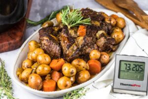 Slow Cooker Beef Stew served in a rustic ceramic bowl with fork-tender beef, golden potatoes, and carrots in a glossy herb-loaded brown gravy, garnished with fresh thyme