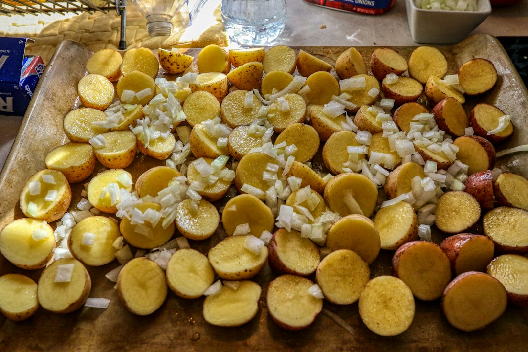 Ingredients for Slow Cooker Beef Stew laid out flat on a wooden surface — cubed chuck roast, Yukon Gold potatoes, carrots, onions, garlic, fresh thyme, rosemary, and jars of Worcestershire sauce and tomato paste