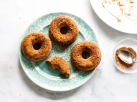 overhead flat lay of apple cider donut ingredients including reduced cider, spices, brown sugar, sour cream, and flour on a marble countertop
