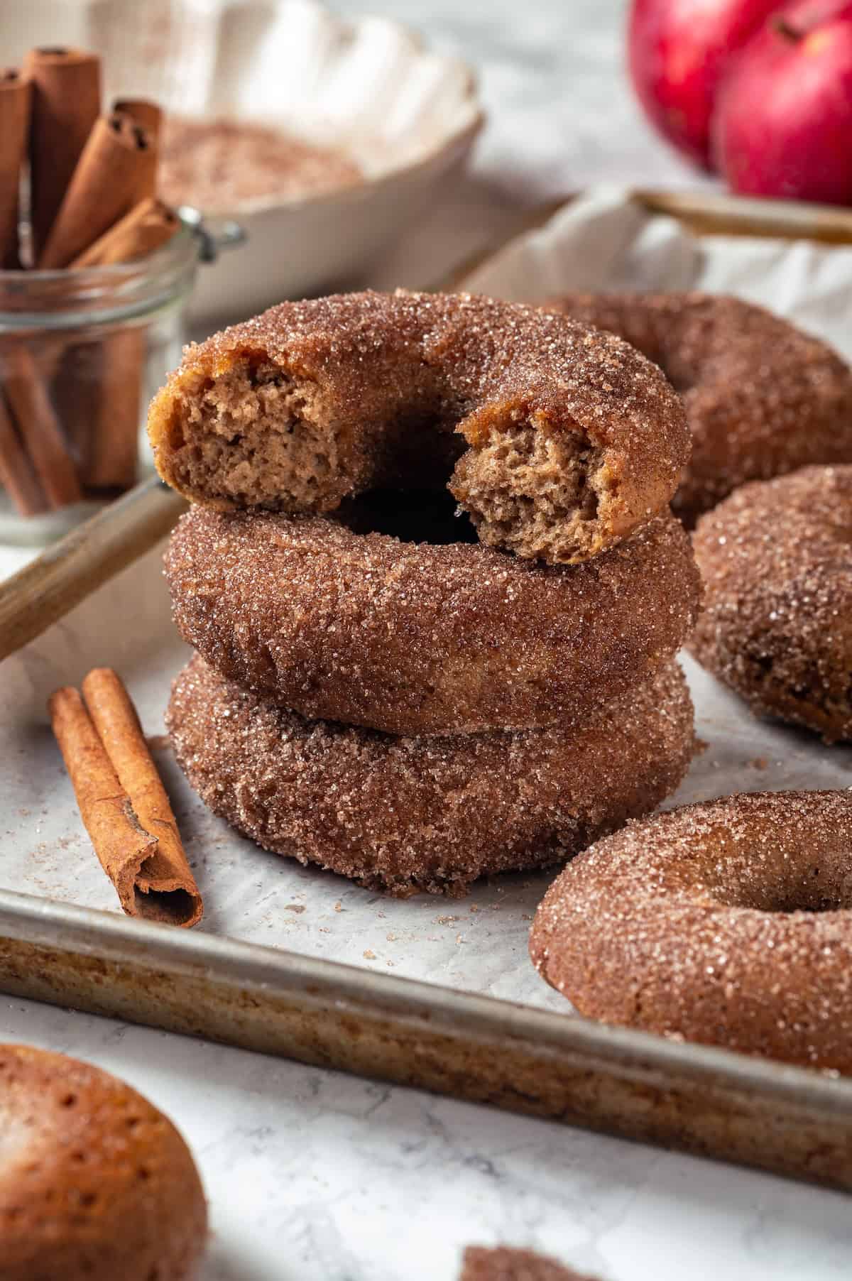 close-up of a halved apple cider donut showing the tender spiced crumb with cinnamon sugar coating glistening on the outside