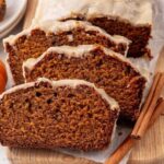 Close-up of a thick slice of pumpkin bread showing the moist, tender crumb interior with a golden crackly cinnamon sugar crust on top