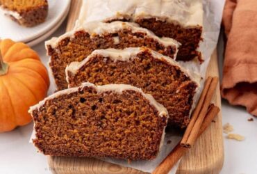 Close-up of a thick slice of pumpkin bread showing the moist, tender crumb interior with a golden crackly cinnamon sugar crust on top