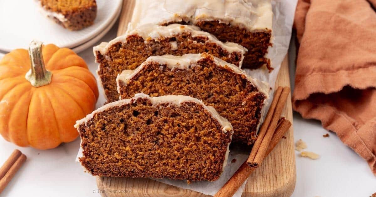 Close-up of a thick slice of pumpkin bread showing the moist, tender crumb interior with a golden crackly cinnamon sugar crust on top