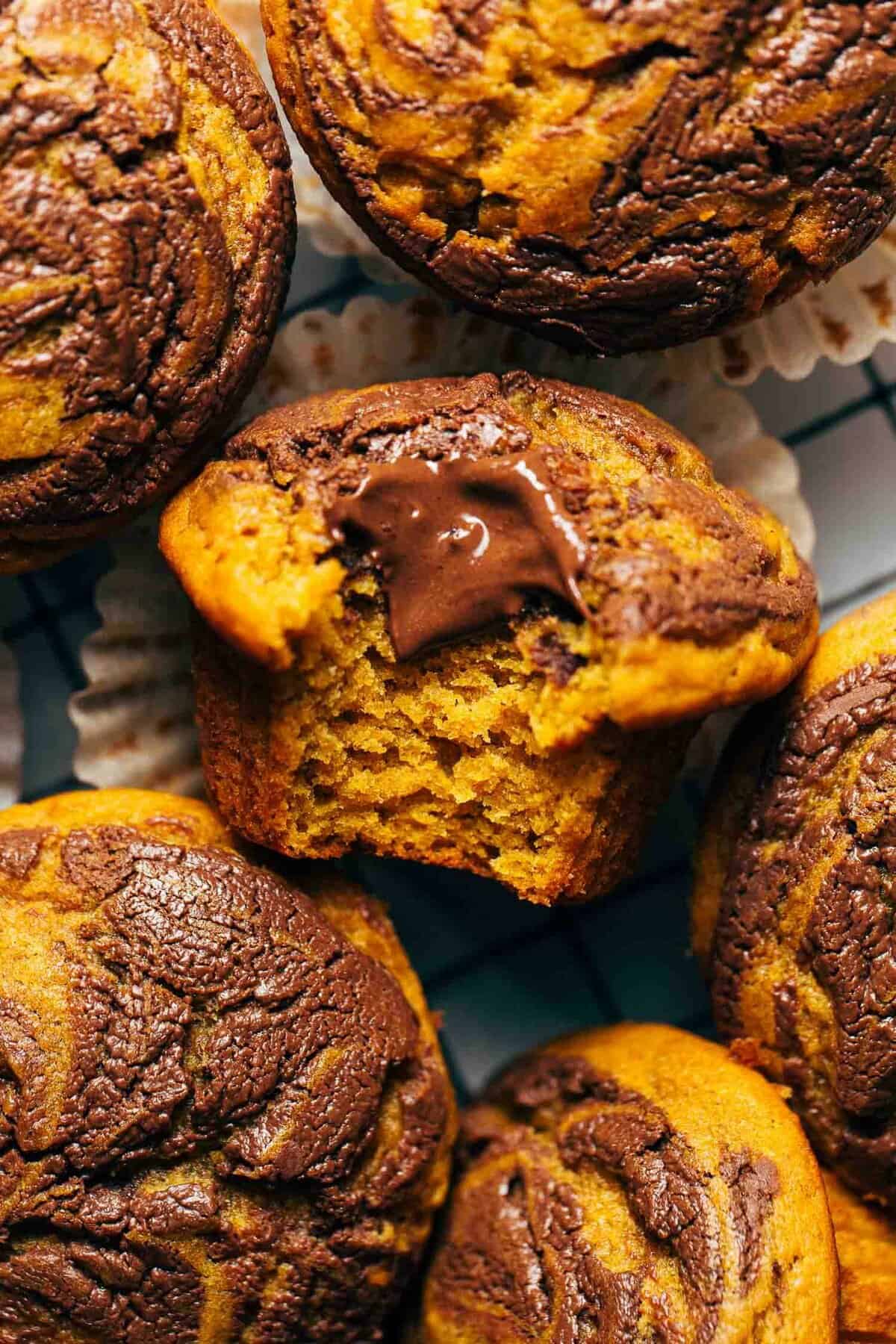 Close-up of a split-open pumpkin chocolate chip muffin showing moist crumb and melted chocolate chip pockets